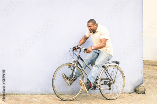 African american guy having fun and good time with vintage bicycle outdoors