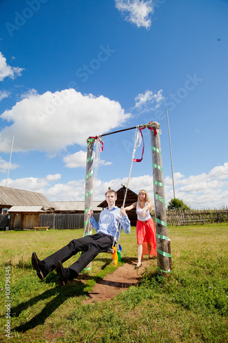 loving couple in the rural landscape. woman in a red dress and a man in a blue shirt