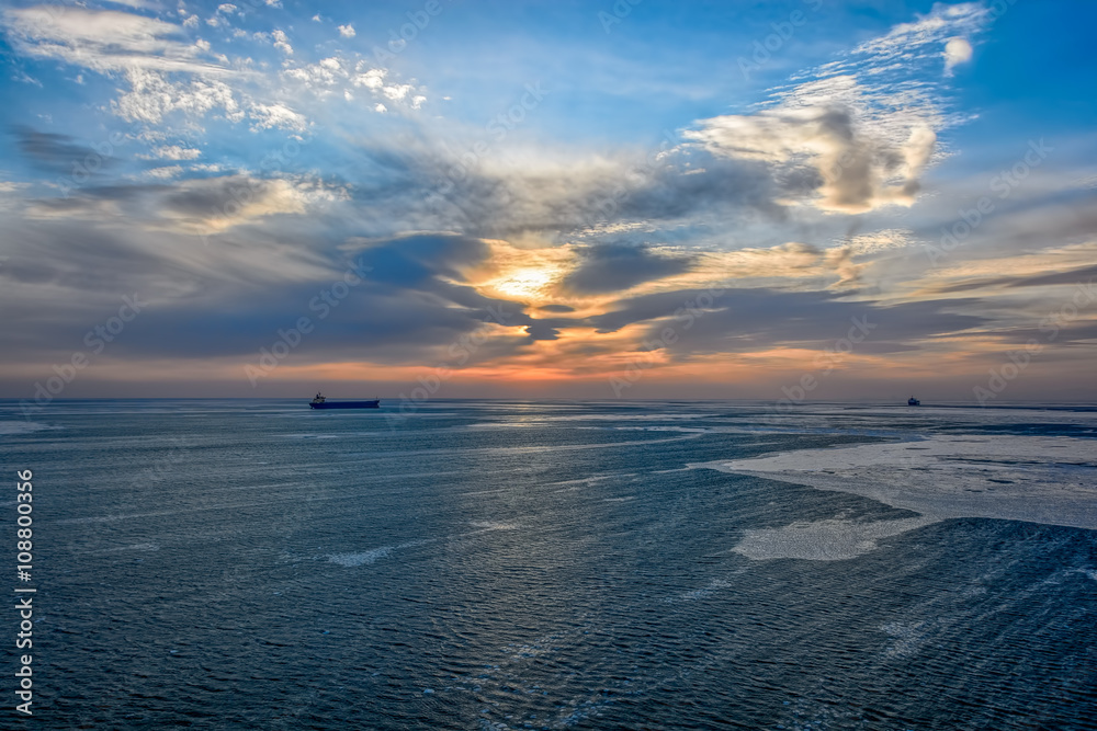 Obraz premium Cargo ship sailing on sunrise