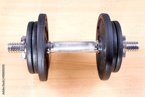 One dumbbell on a wooden floor.
