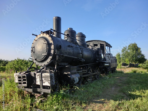 Vintage old antique train locomotive engine perspective in sun - landscape color photo