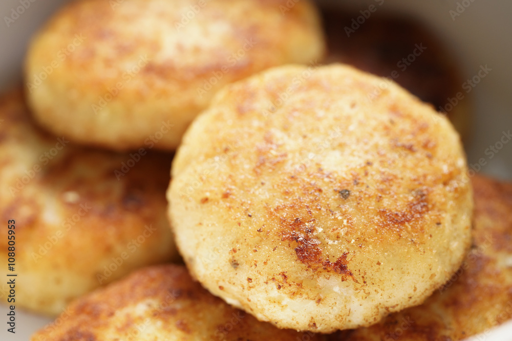 prepared fried fish cakes in bowl, shallow focus