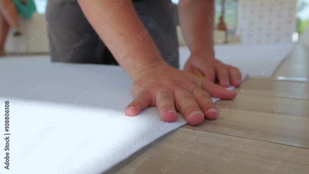 a man's hand glues to the white carpet to the floor for a wedding ceremony. CU, dolly a man's hand glues to the white carpet to the floor for a wedding ceremony. CU, dolly