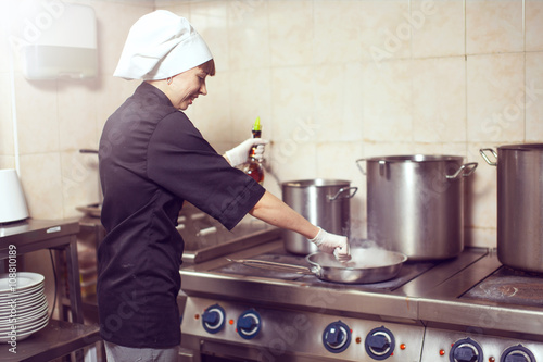 Fototapeta Naklejka Na Ścianę i Meble -  Chef Cooking With Fire In Frying Pan
