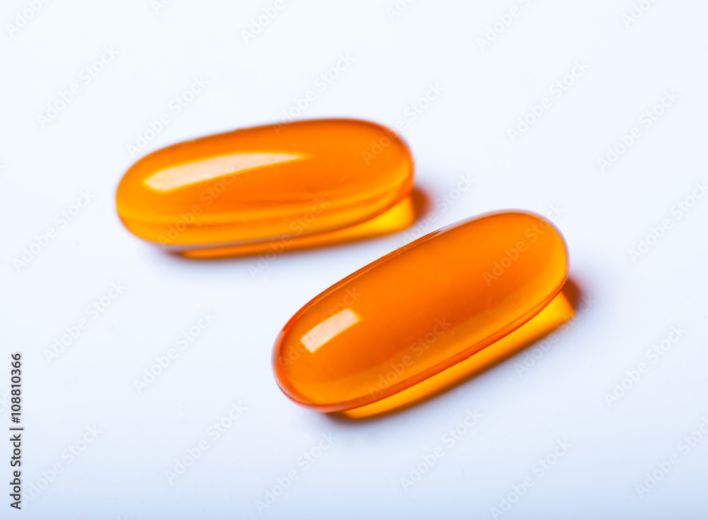 macro photo of two orange pills isolated on white background macro photo of two orange pills isolated on white background