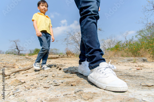 Two Boy walking on the rocky land.