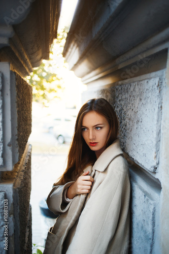 Beautiful young blond girl posing in the street.