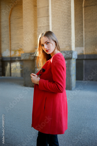 Beautiful young blond girl posing in the street.