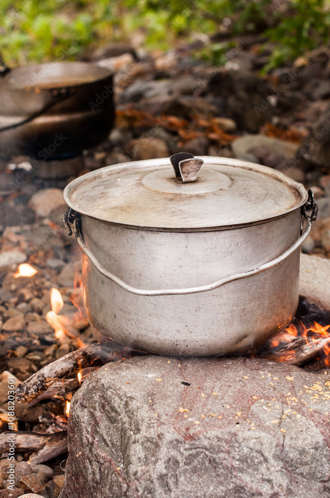 Preparing food on campfire in wild camping Preparing food on campfire in wild camping