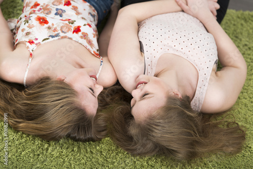 BFF Zwei Mädchen liegen als beste Freundinnen gemeinsam auf Teppich