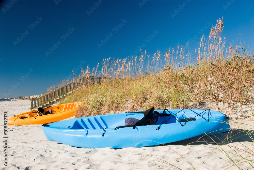 Two Fishing Kayak Boats Parked on a Sand Dune at the Beach