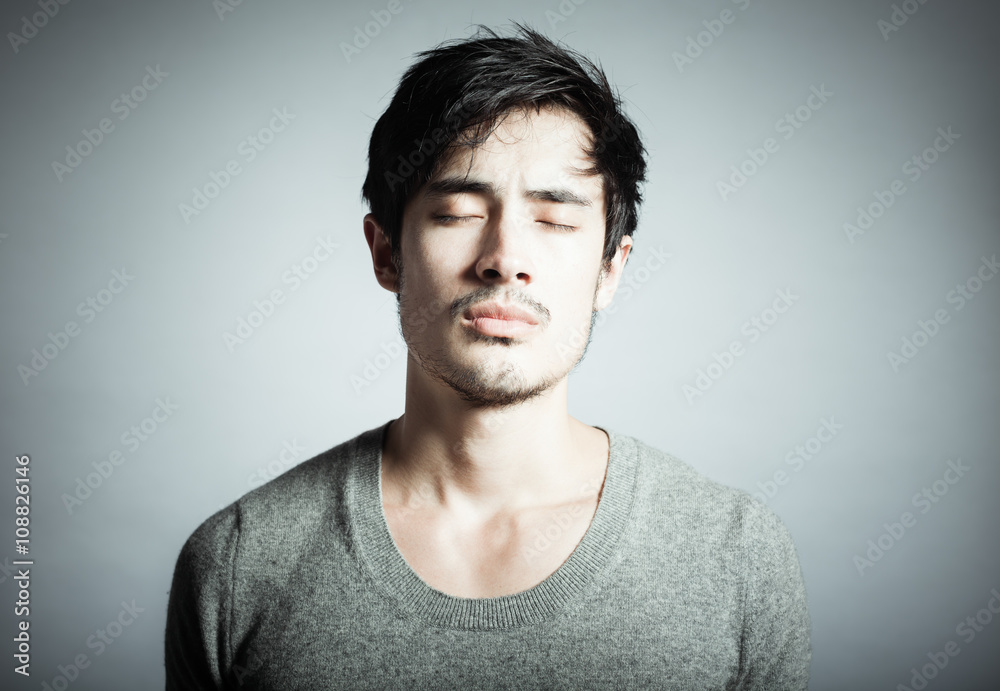 Fototapeta premium Thoughts and feelings concept. Portrait of young man in studio thinking. 
