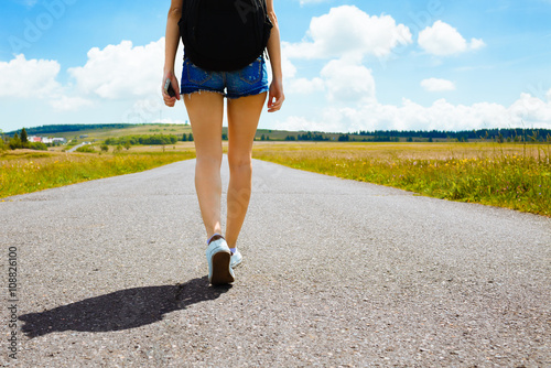 Woman traveling down country road. 