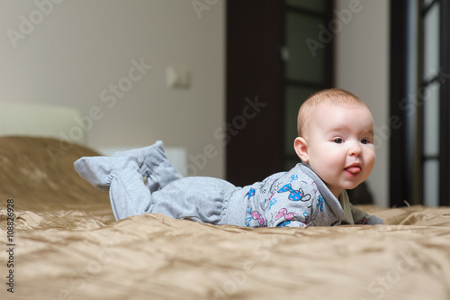 Obraz na płótnie Baby girl lying on belly and grimacing