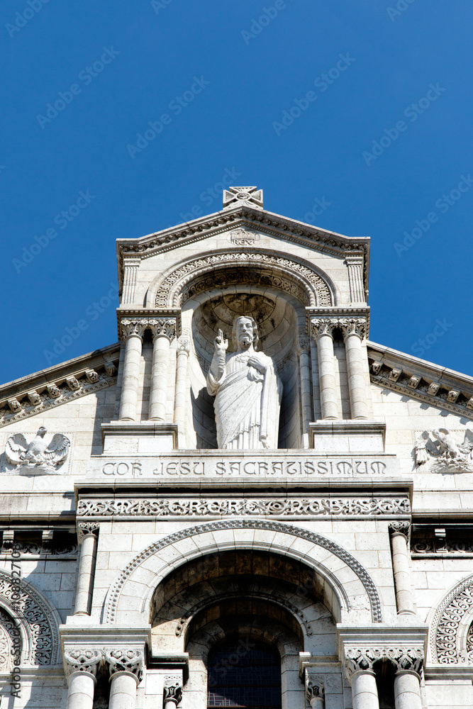 Color DSLR image of Basilica of the Sacre Couer on Montmartre, Paris, France with clear blue sky. Catholic church cathedral is popular Europe tourist destination. Vertical with copy space for text.