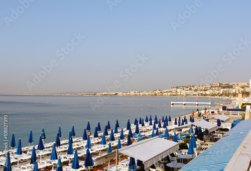 Color DSLR stock image of beach in Nice, France on the Mediterranean French Riviera Coast, with lounge chairs and umbrellas. Horizontal with copy space for text © Richard McGuirk