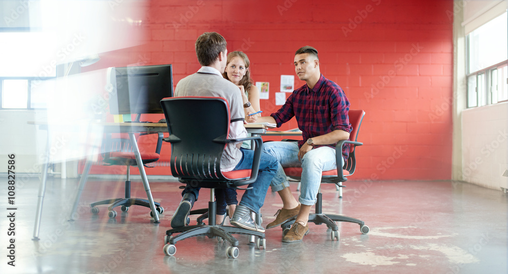Unposed group of creative business people in an open concept office brainstorming their next project.