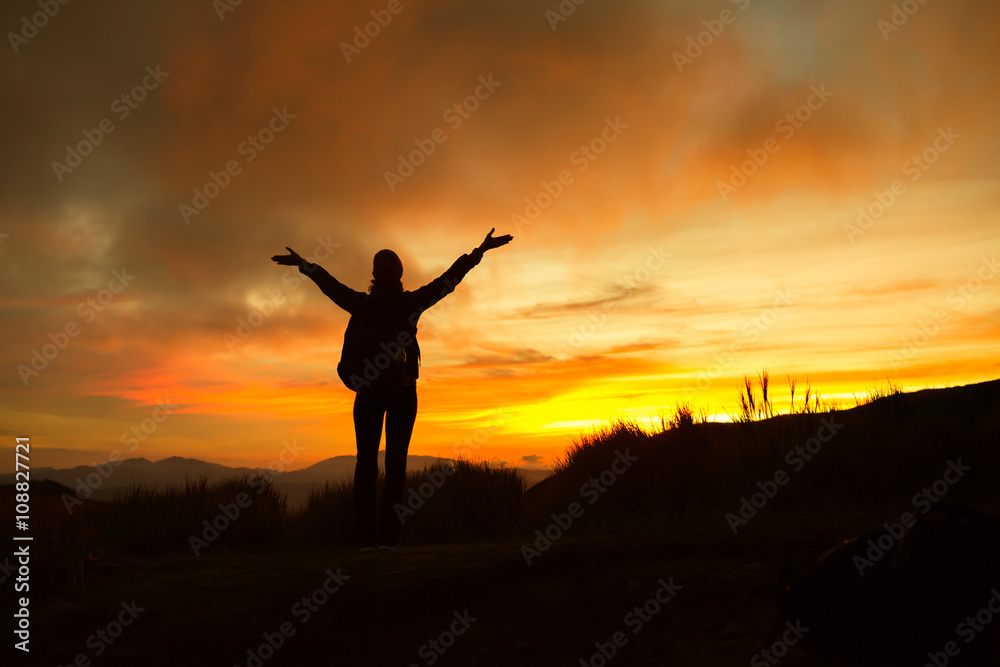 Enjoying the great outdoors! Female hiker celebrating during a beautiful sunset. 