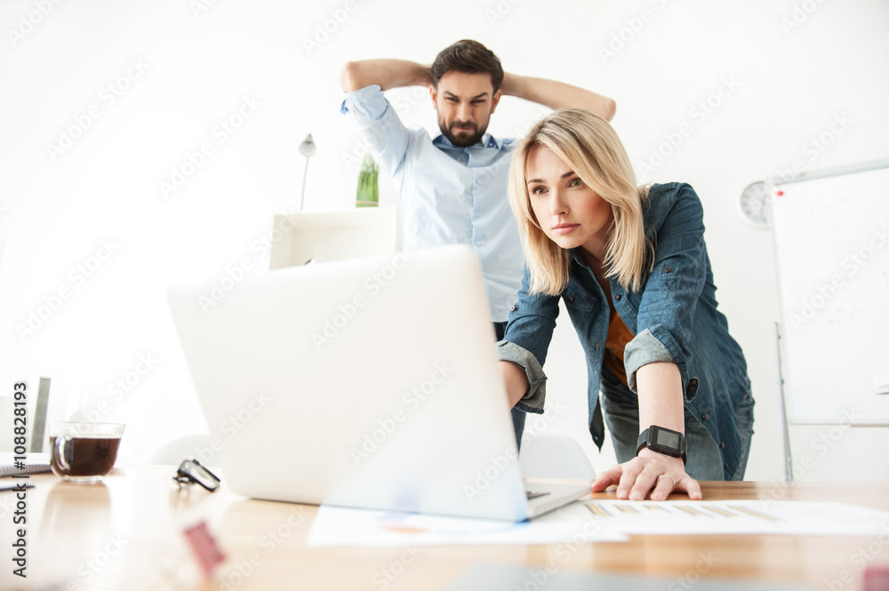 Cheerful two colleagues are working on a project Cheerful two colleagues are working on a project