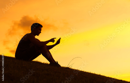 Young man using his smartphone outdoors.
