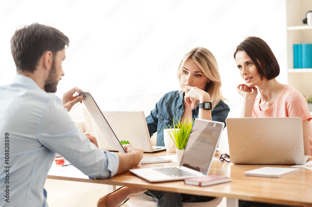 Cheerful three workers are discussing new project Cheerful three workers are discussing new project