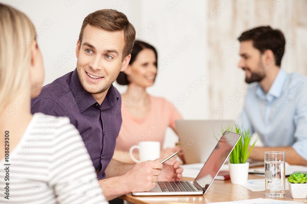 Cheerful creative team is working in office
