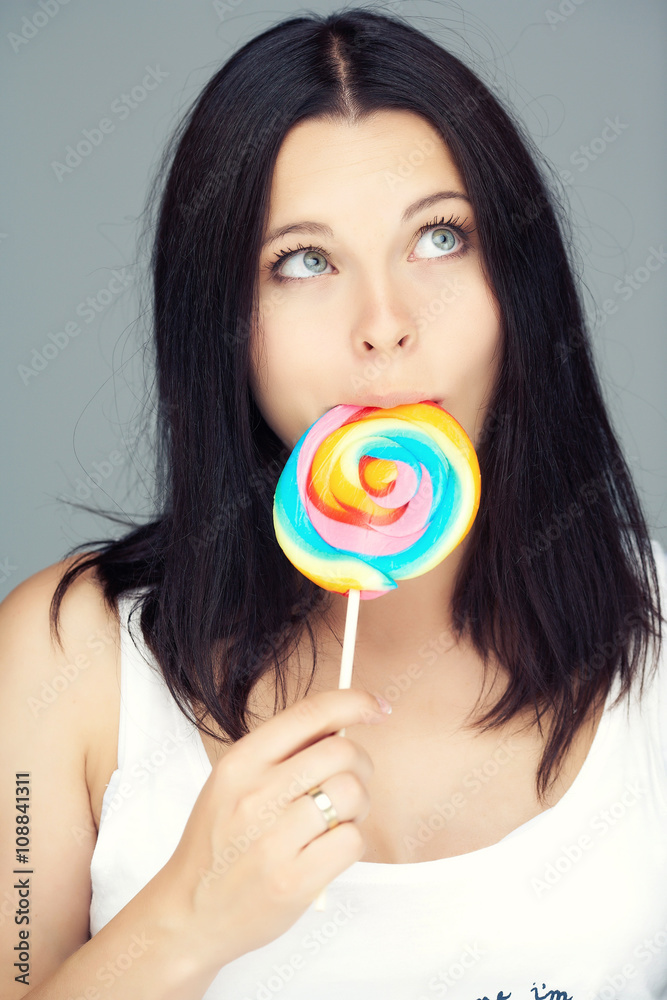 Portrait of brunette female with colored candy.