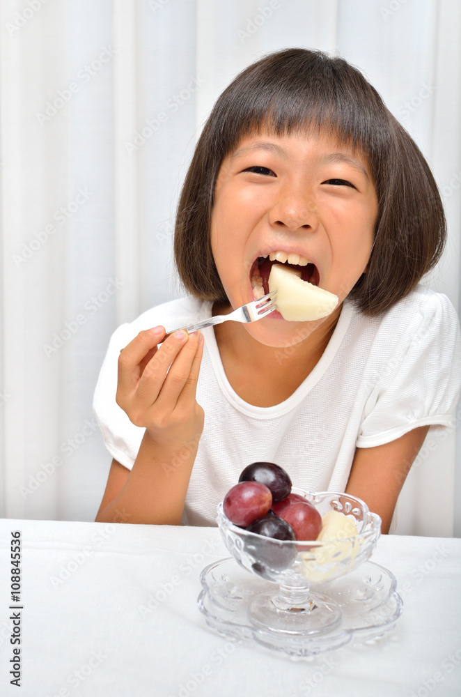 フルーツを美味しそうに食べる女の子