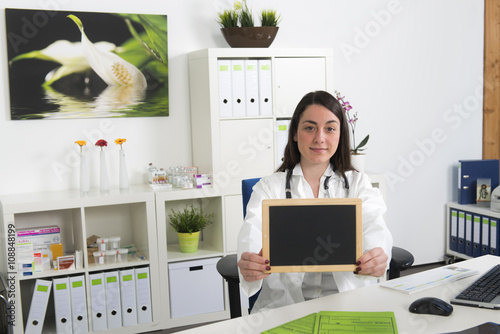 Aezthelferin bzw. Ärtztin hält leere Tafel in die Kamera photo