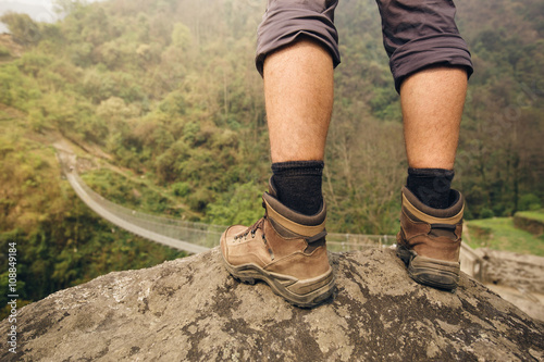Hiker shoes on hiker legs standing above bridge © yossarian6