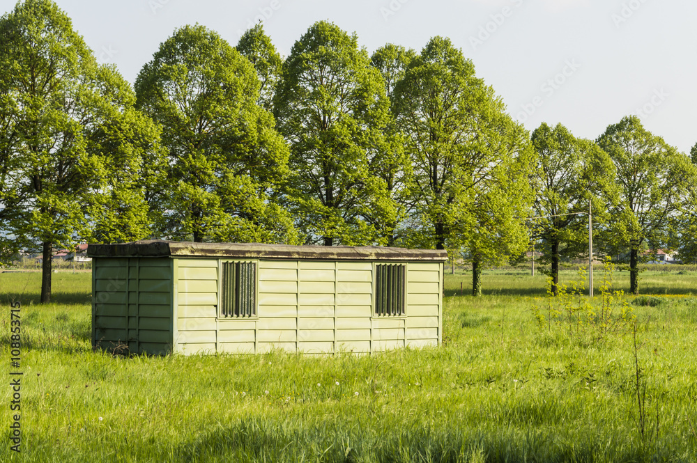 A metal hut in a green and sunny field