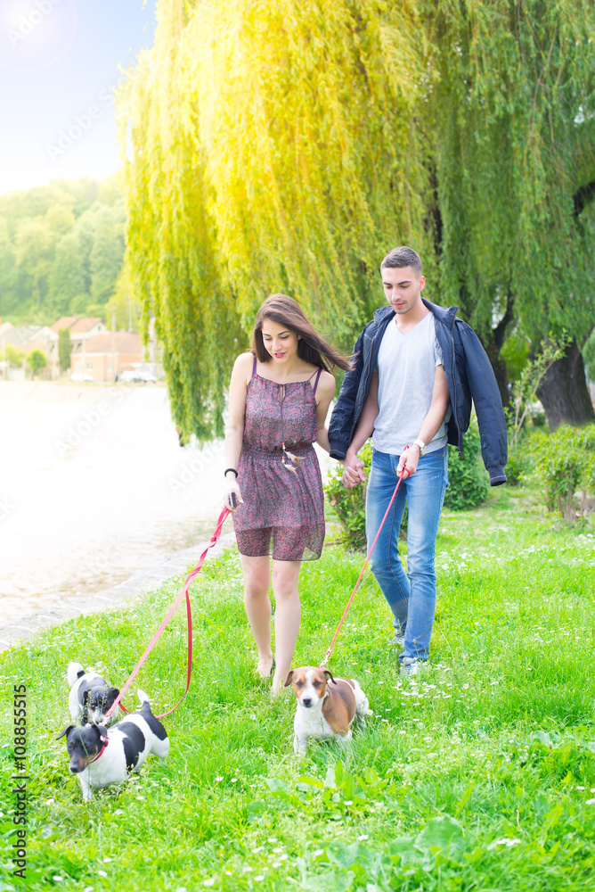 Fototapeta premium Young couple in love,walking and enjoy in park with his dogs