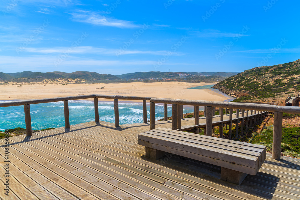 Wooden platform and view of sandy Praia do Bordeira beach, Algarve region, Portugal