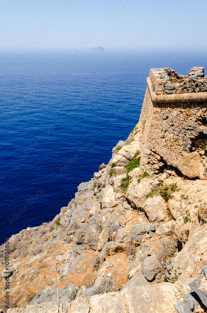 The view from the walls of the dilapidated old stone fortress of the turquoise sea and the distant horizon