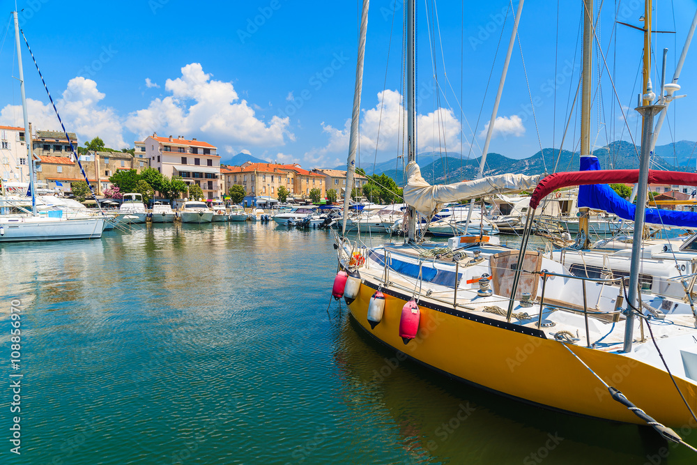 Sailing boats in Saint-Florent fishing port on sunny summer day, Corsica island, France