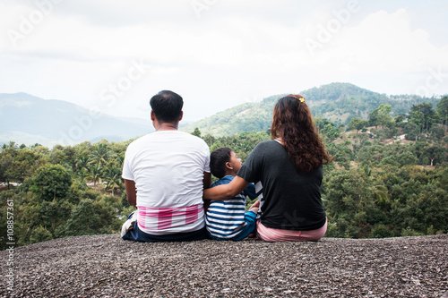 Rear of family sitting on the stone natural background
