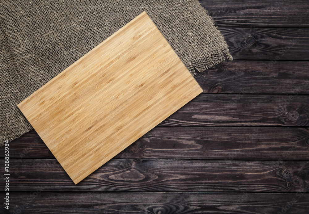 Cutting board on dark old wooden table. Top view Cutting board on dark old wooden table. Top view