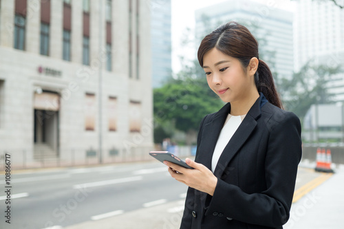 Businesswoman sending sms on mobile phone © leungchopan