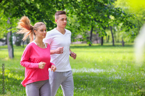 Fototapeta Naklejka Na Ścianę i Meble -  Running couple jogging in the park
