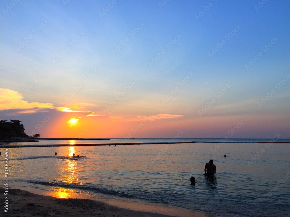 tourists swiming under sunset