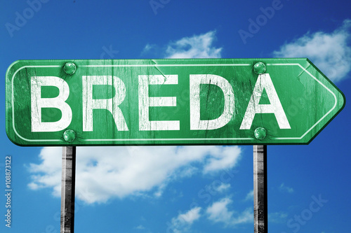 Breda road sign, vintage green with clouds background