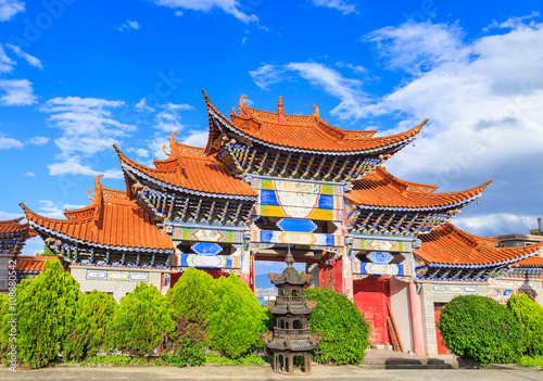 Arched  entrance of Chinese temple under blue sky and white clou