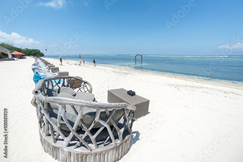 Tropical sandy beach with buildings and boats in a sea. Gili Tra photo