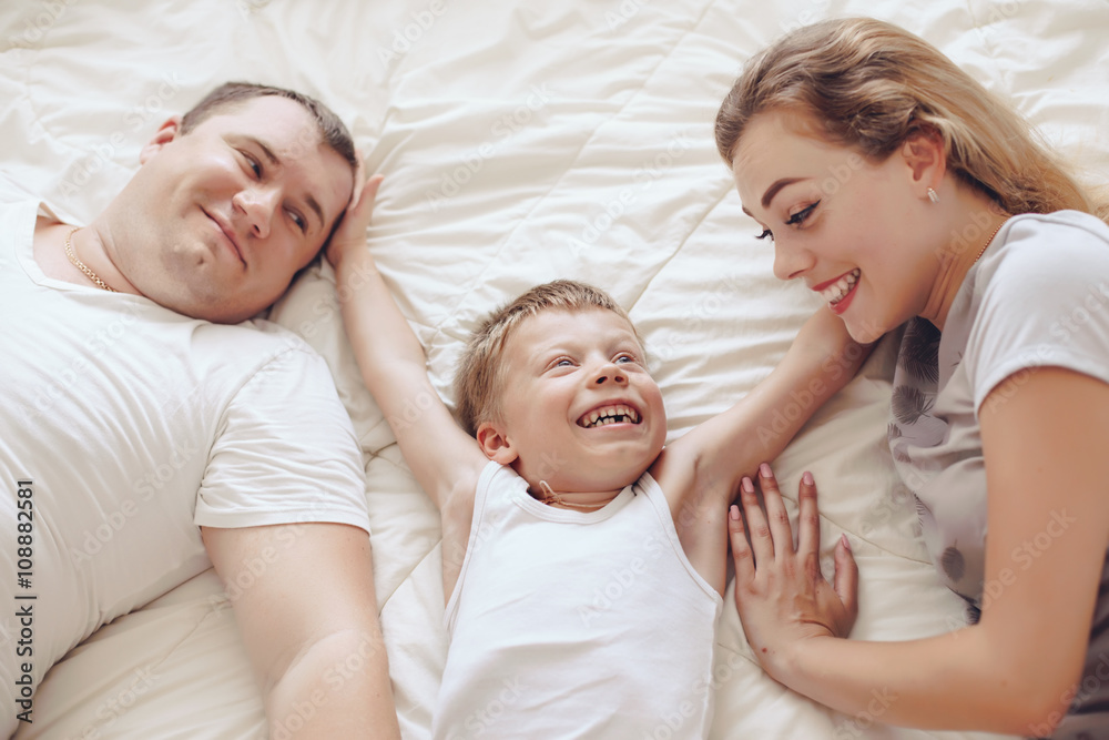 Happy family relaxing in bed