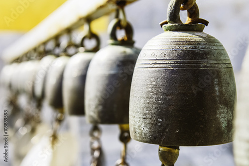 Принти на полотні Many golden buddhist bells with wishes in sunlight