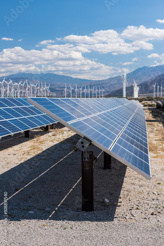 Solar panels and wind turbines in sunny desert
