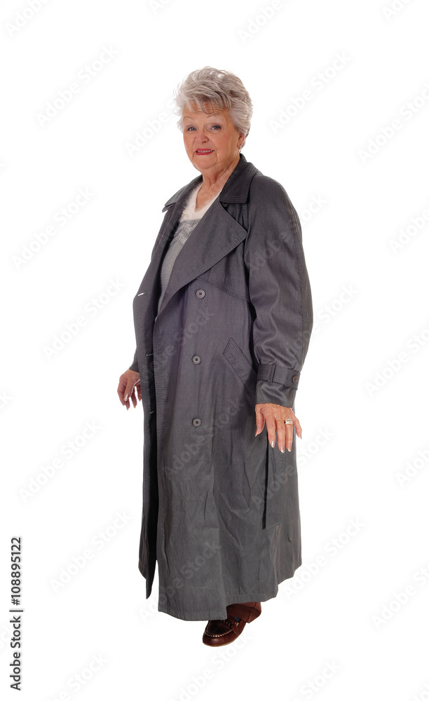 Senior woman standing in a long coat.