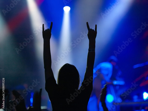 Girl raising up hands on rock concert