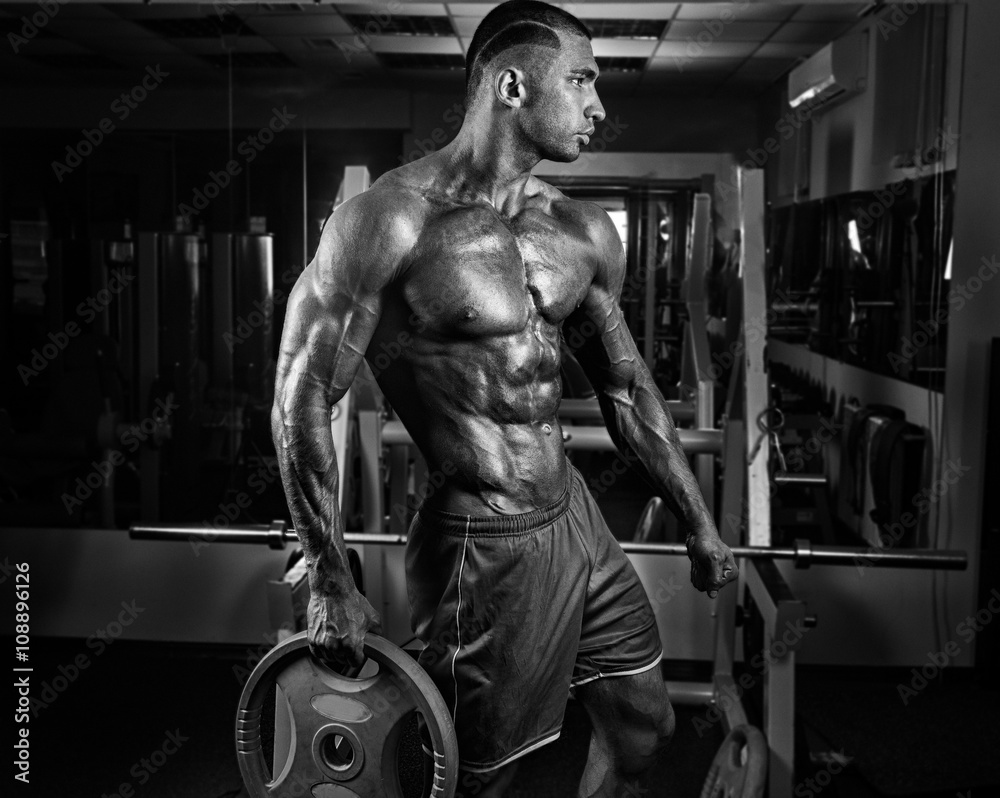 Fototapeta premium Muscular athletic bodybuilder fitness model posing after exercis