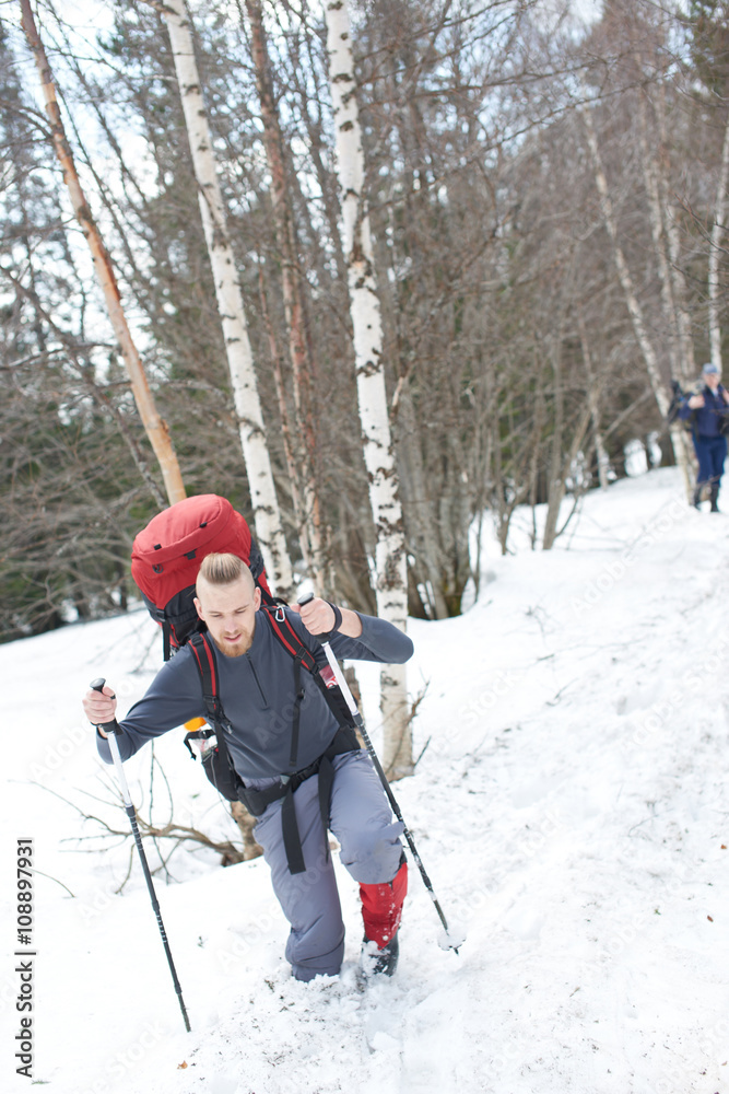 Guy tourist makes the ascent to the mountain in deep snow Guy tourist makes the ascent to the mountain in deep snow